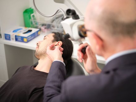 ENT voice doctor David Vokes performs a physical and visual examination of patient who is lying back relaxed on chair, he is using specialist equipment to thoroughly examine the different areas of the Ear, Nose and Throat, Ent Specialist Auckland, ENT Surgeon Auckland NZ, Otolaryngology Clinic